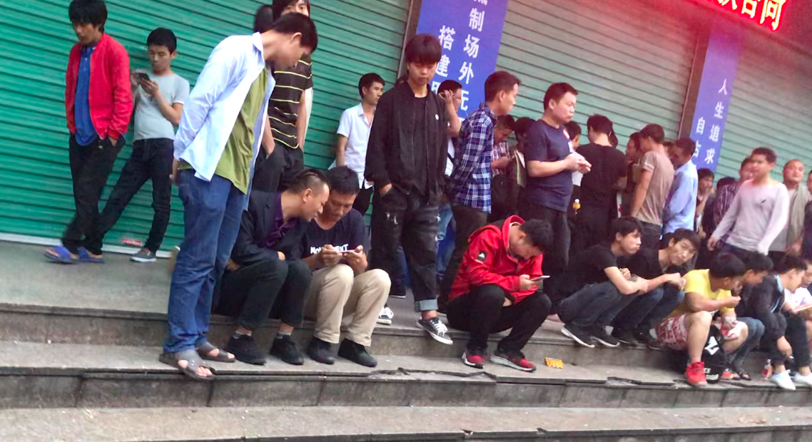 Homeless people gather outside Haixinxin Human Resources Market