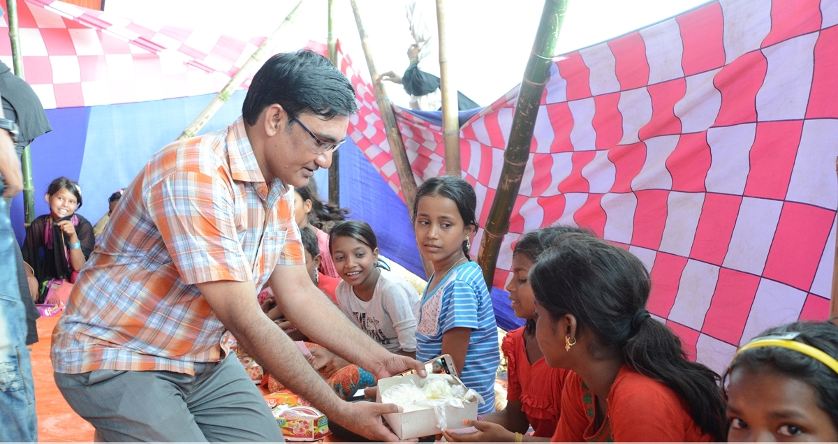 James Gomes, a director of Caritas Bangladesh shares meal with Rohingya refugee in a camp