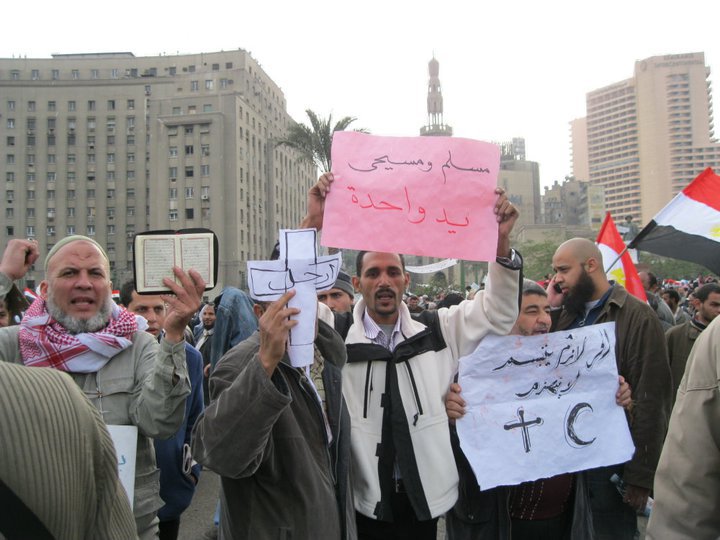 Manifestanti con cartello che recita: “cristiani e musulmani una mano sola”