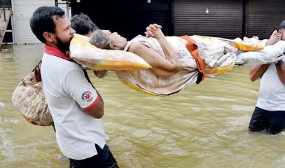 Amidst_the_flood_situation_in_the_Gampaha_area,_a_group_of_individuals_are_seen_carrying_an_elderly_woman_to_a_hospital_due_to_a_medical_emergency._Pix_by_Kushan_Pathiraja.jpg